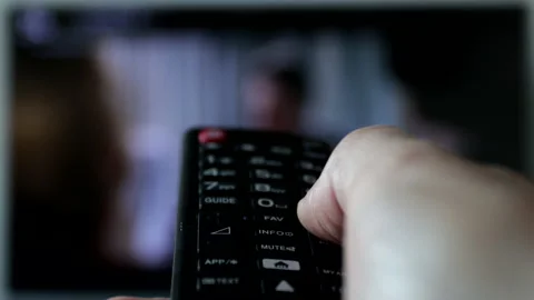 Close-up of a remote control held by a man while changing channels. Stock Footage 239015443