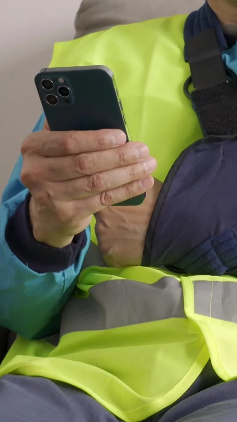 Close up of repairman hands with broken arm wearing sling using smart phone a Vidéo 337033480