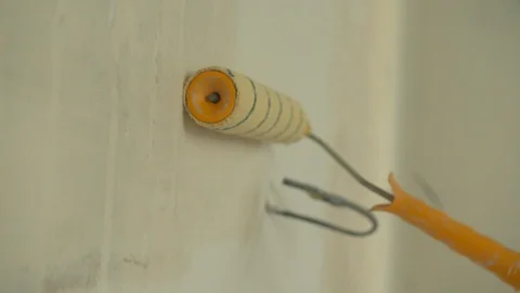 Close up, repairman paints a wall in the flat Stock Footage 124843121