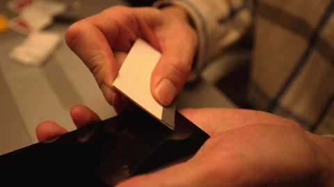 Close-up of repairman skillfully using bubble-free glass screen application Stock Footage 304884745
