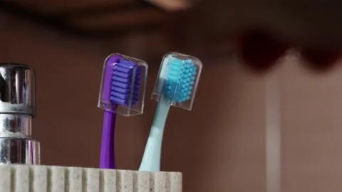 Close up replacing two old worn toothbrushes with new clean ones Stock-Footage 344876984