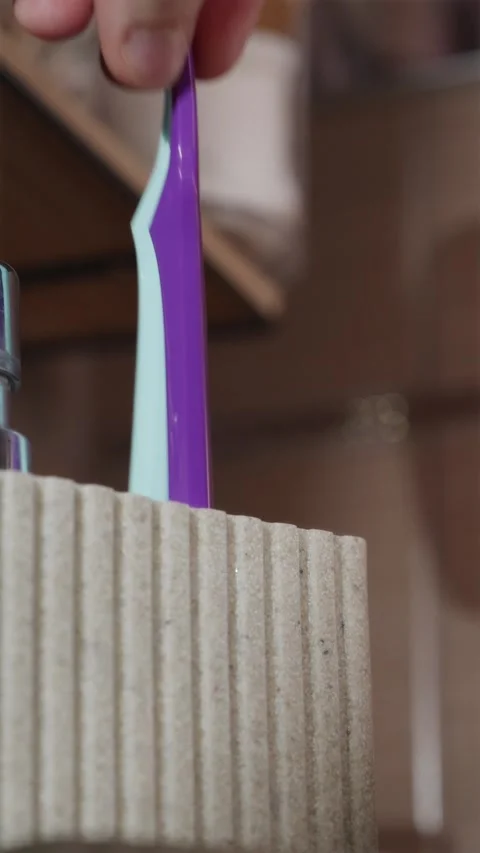 Close up replacing two old worn toothbrushes with new clean ones Stock Footage 344877014