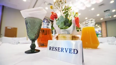 Close-up of a reserved sign on a restaurant table with a white tablecloth. Stock Footage 328307546