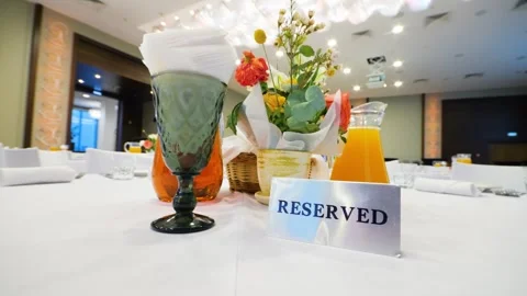 Close-up of a reserved sign on a restaurant table with a white tablecloth. Stock Footage 328307597