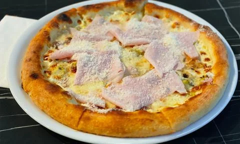 Close-up on a restaurant table pizza with prosciutto cotto and taleggio cheese Stock Photos