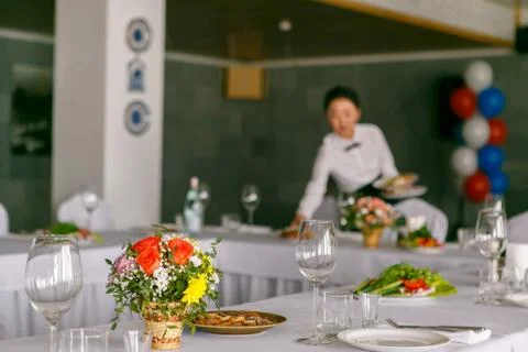 A close up of restaurant table set with the waitress in the backgroung Stock Photos