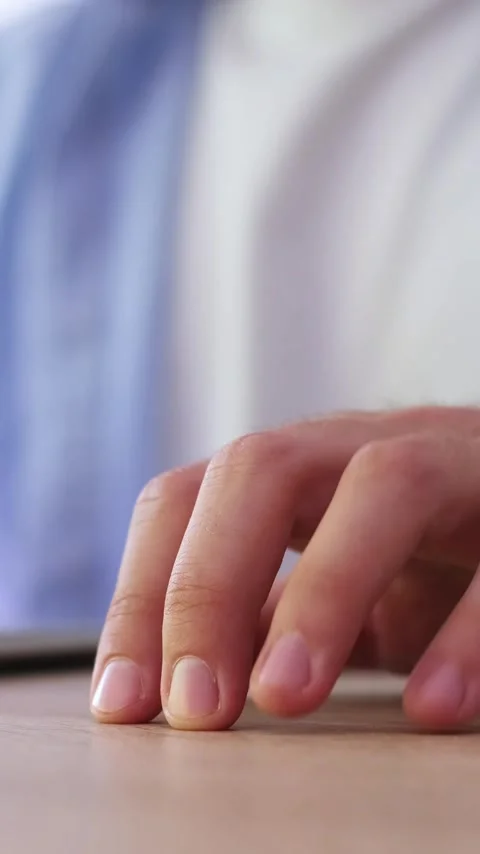 Close-up of a restless man's hand, his fingers drumming impatiently on a wooden Stock Footage 344757601