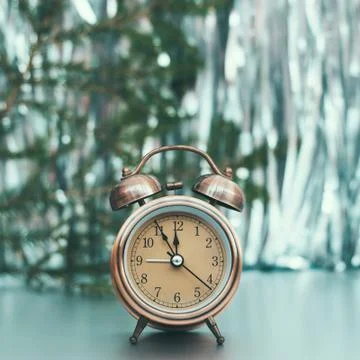 Close up of retro alarm clock on blurred Christmas background with bokeh Stock Photos