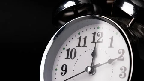 Close-up of a retro alarm clock face in time lapse on black background. Stock Footage 260682794