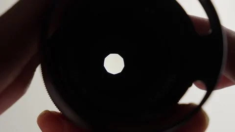Close-up reveals lens interior, hands changing aperture, precision in Stock Footage 275773110