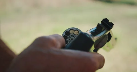 Close up of revolver being loaded with bullets outdoors Stock Footage 311489228