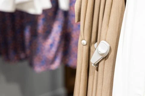 Close-up of RFID theft security tag attached onto apparels in clothing shop Stock Photos