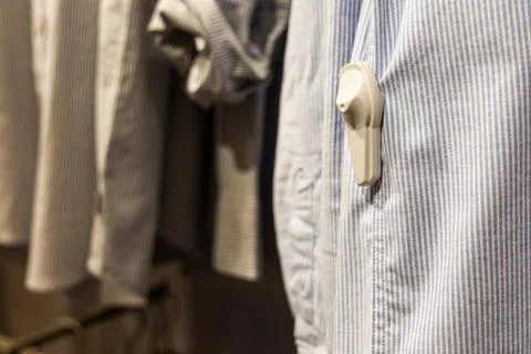 Close-up of RFID theft security tag attached onto apparels in clothing shop Stock Photos