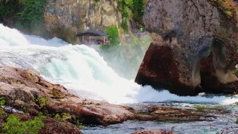 Close-up of Rhine Falls cascade with rocky pillar and mist Stock Footage 315246780