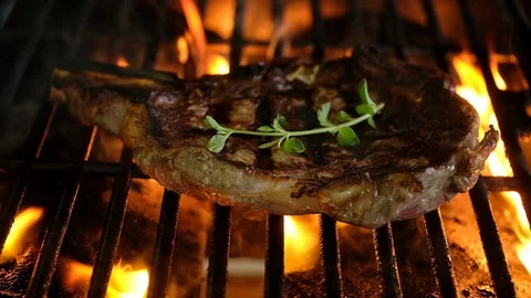 Close-Up Of Rib Eye Steak Grilling On Barbecue Stock Footage 100351725