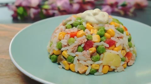 Close-up of rice salad with vegetables and dressing on green plate indoors 库存影片 342884543