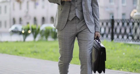 Close-up of a rich businessman with a briefcase drinking coffee in a summer park Stock Footage 116080743