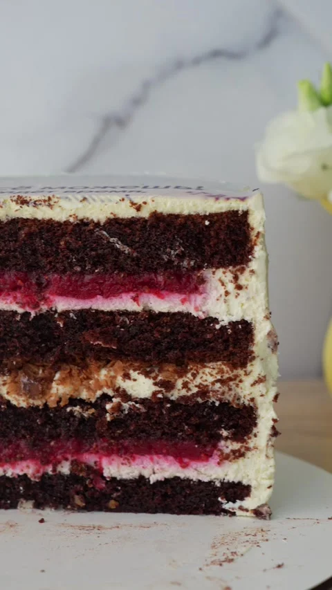 Close-up of rich chocolate cake slice with layers of creamy frosting, Stock Footage 297775214
