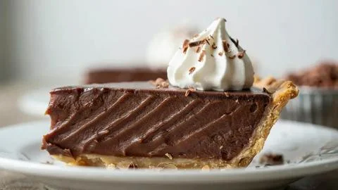 Close-up of a rich chocolate cake slice topped with whipped cream and chocolate Stock Photos