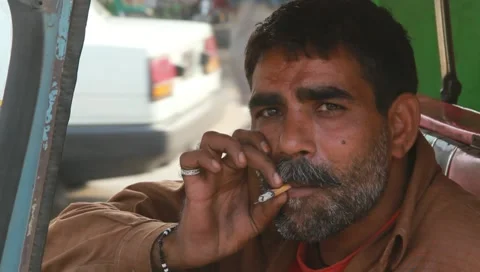Close up of a rickshaw driver Smoking Cigarette Stock Footage 10795407