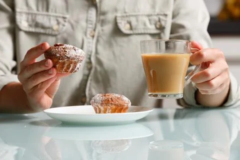 Close up of right hand taking one of two curd muffins from plate, and left .. Stock Photos
