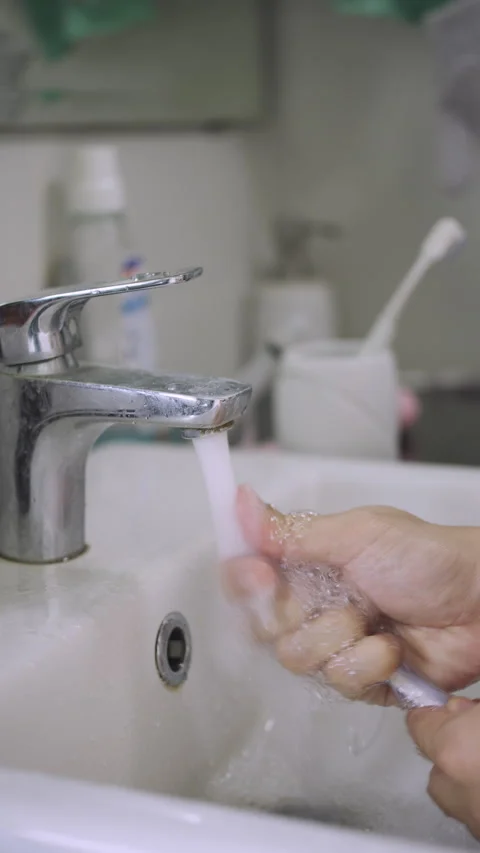 Close-up of Rinsing Toothbrush Under Running Tap Water Faucet. Stock Footage 337769597
