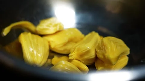 Close up of ripe jackfruit pieces in a dark bowl with soft light reflection 動画素材 339022551
