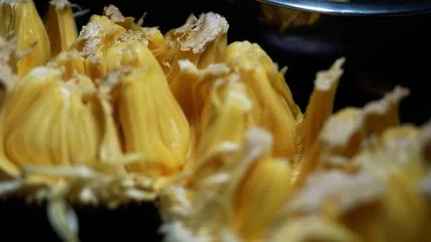 Close-up of ripe jackfruit pieces with yellow flesh and fibrous texture on .. Stockbeeldmateriaal 339022523