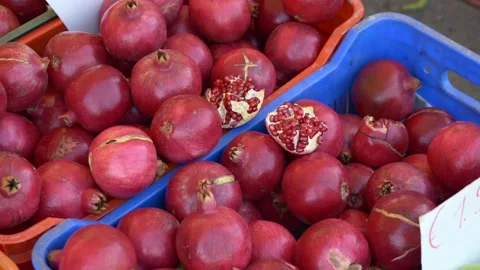 Close up ripe pomegranates in crates with cut fruit revealing ruby arils, juicy Stock Footage 321817091