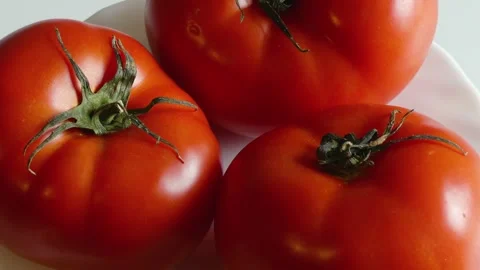 Close-Up of Ripe Tomatoes Rotating on a White Plate Vídeo Stock 256421898
