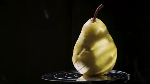 Close-up of a ripe yellow pear against a dark background Stock Footage 345087653