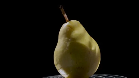 Close-up of a ripe yellow pear against a dark background Stock Footage 345087720