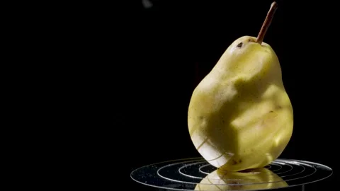 Close-up of a ripe yellow pear against a dark background Stock Footage 345087730