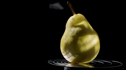 Close-up of a ripe yellow pear against a dark background Stock Footage 345087731