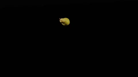 Close up at ripe yellow pear flies up and spinning on a black background Stock Footage 152789331