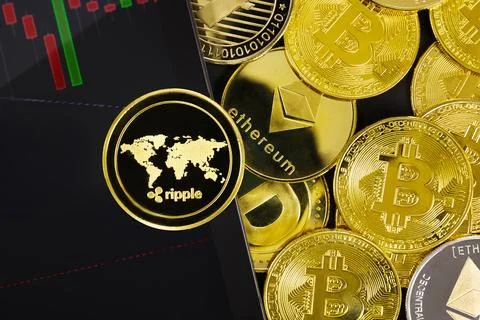 Close-up of Ripple by graph on digital tablet near various coins Stock Photos