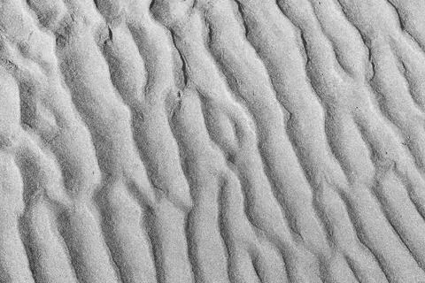 Close up of rippled sand texture background with natural wave patterns in beach 写真素材