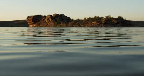 Close up. Ripples running over the still water surface in sunset lighting. Stock Footage 142130111