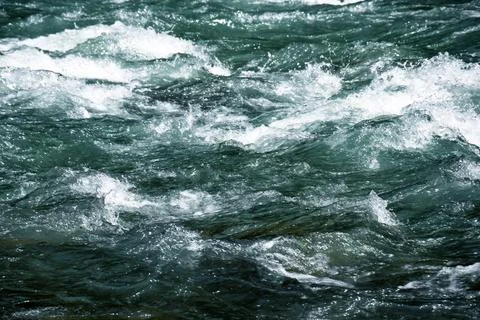 Close-up of a river flow on the rocks. Clean bubbling transparent blue wate.. Stock Photos