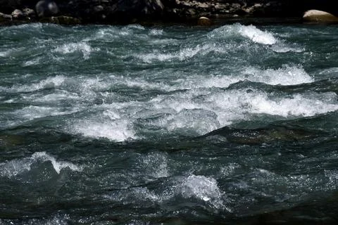 Close-up of a river flow on the rocks. Clean bubbling transparent blue wate.. Stock Photos