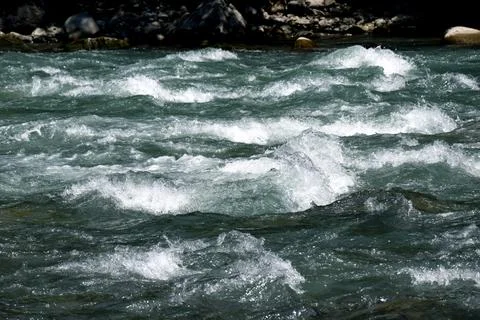 Close-up of a river flow on the rocks. Clean bubbling transparent blue wate.. Stock Photos