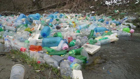 CLOSE UP: River stream running under giant floating pile of plastic bottles Stock Footage 195019639