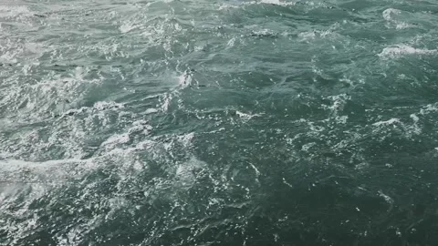 Close-Up of River Water Surface with Gentle Ripples and Bubbles Stock Footage 313599168