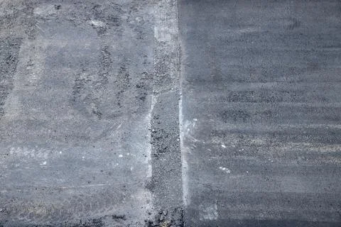 Close-up of a road resurfacing process showing the contrast between old and new Stock Photos