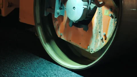Close-up of a road roller drum. Night time. Road construction equipment. Road Stock Footage 152605571