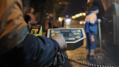 Close-up of a road worker clicks on the buttons on the paver's control panel Stock Footage 163237746