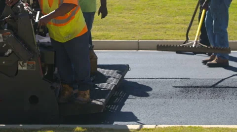 Close Up Road Workers Smooth Asphalt in Slow Motion Stock Footage 68650756