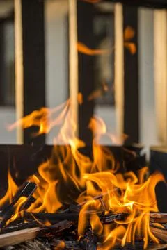 Close-up, roaring fire with blurred flames from wood logs in a stone firepit. 스톡 사진