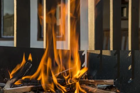 Close-up, roaring fire with blurred flames from wood logs in a stone firepit. Stock-Fotos