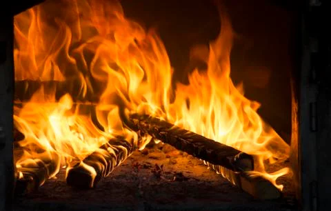 Close up of roaring fire burning brightly in fireplace. Warmth in winter time. Stock Photos